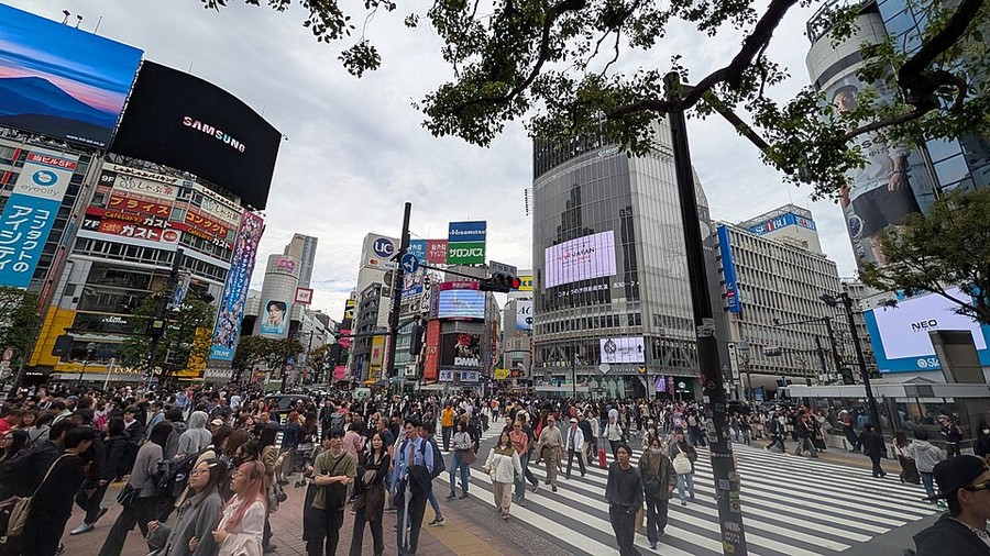 Pietoni traversând intersecția Shibuya, în Tokyo